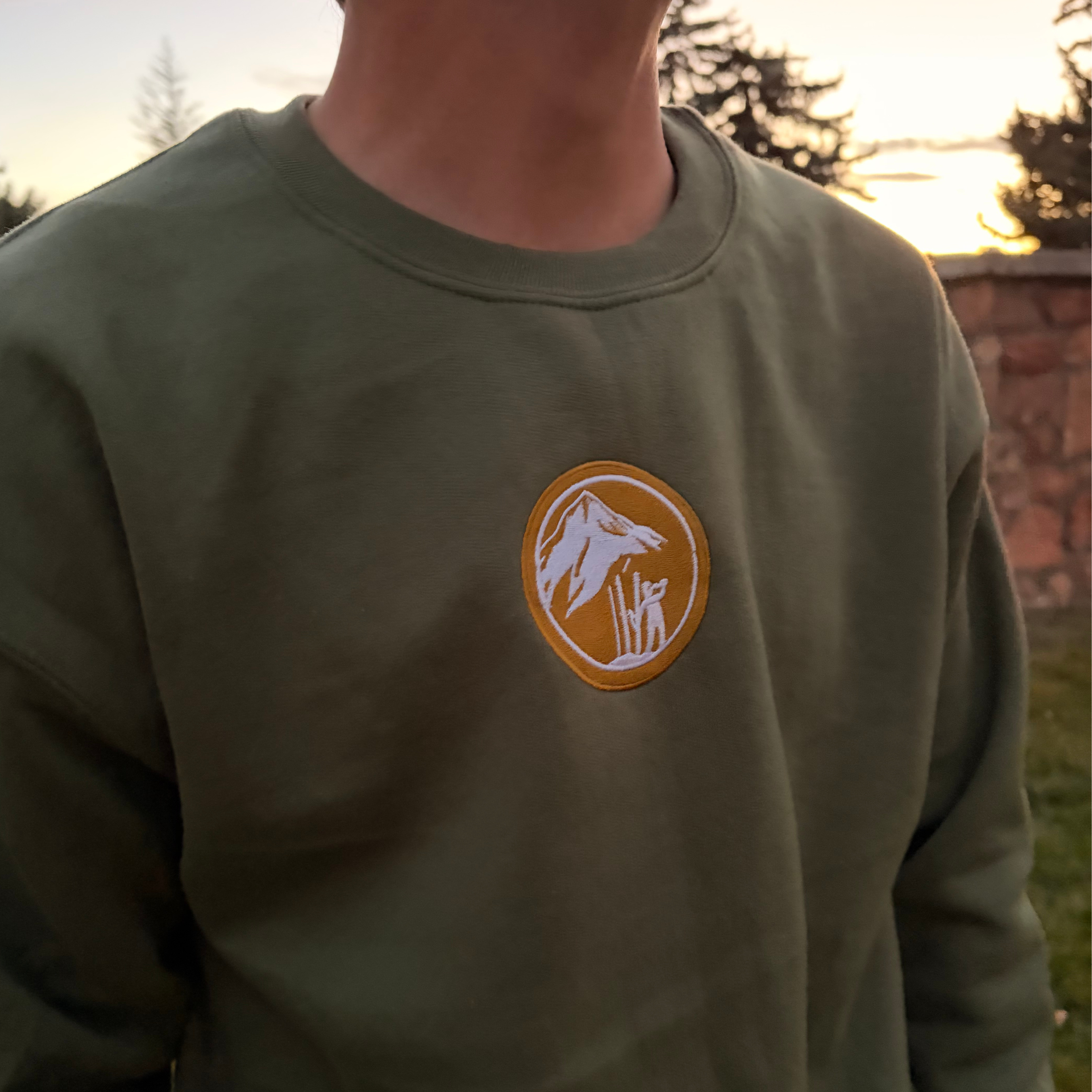 Green Crewneck with Mountains and Skier drinking a beer.